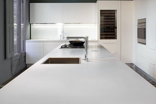 A kitchen with white cabinets and a white countertop