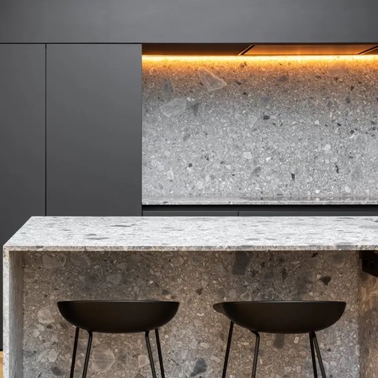 a Uniceramica Ceppo Di Gre island waterfall in a dark kitchen and two stools