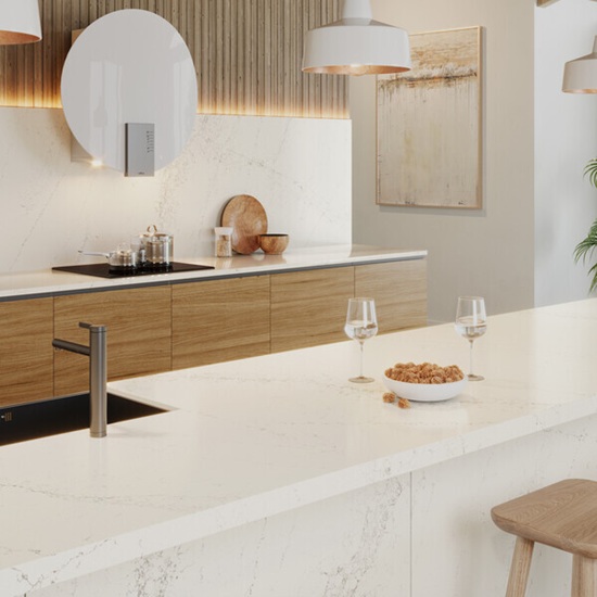 a kitchen with woden doors and Caesarstone Solenna worktops and island