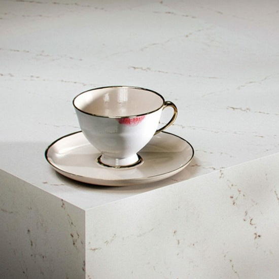 A Caesarstone Aterra Blanca worktop and a small cup marked with a lip balm stain.