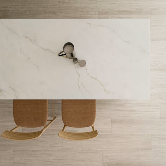 Overhead view of Dekton Keena table with metal pitcher and wooden stools