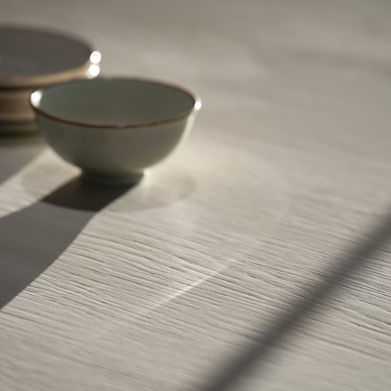 Dekton Zira surface with stacked ceramic bowls in soft lighting