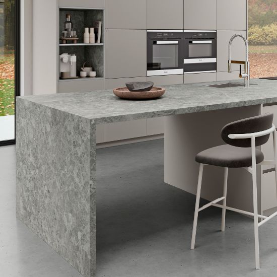 Neolith Cappadocia Sunset kitchen island worktop in grey veined stone with neutral cabinets, sink, bowl, and outdoor view