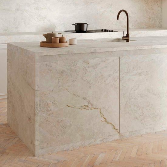 Neolith Everest Sunrise kitchen island worktop with sink, brass tap, and cooking setup on herringbone floor