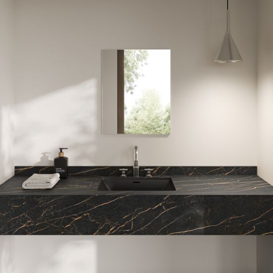 Neolith Mamba bathroom vanity worktop in deep black with golden veining, integrated sink, soap dispenser, and pendant light