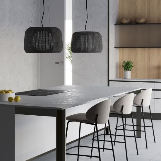 Neolith Whitesands extended kitchen island with induction hob, bar stools, and hanging lights in airy contemporary setting