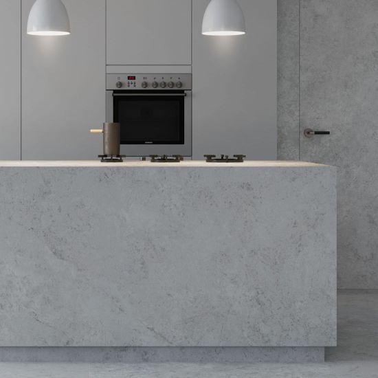 Neolith Whitesands large kitchen island worktop with gas hob, oven, and pendant lights in neutral modern kitchen