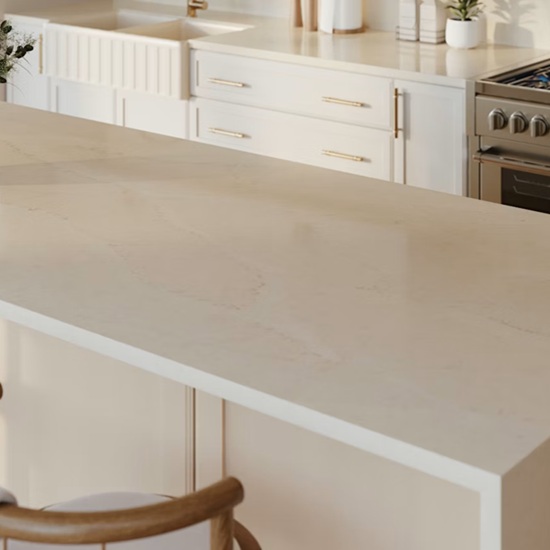 Kitchen countertop in Silestone Calacatta Tova quartz with sink, drawers, and stove in a light-filled white kitchen
