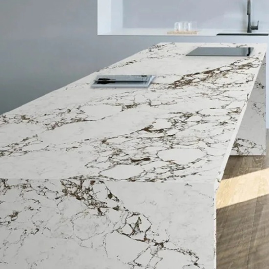 Arabescato Levanto Supreme quartz kitchen island worktop in white with brown and grey veins, featuring a laptop, notebook, and pen in a modern minimalist setting
