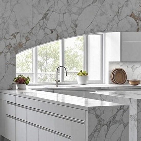 Arabescato Oro quartz kitchen worktop in white with gold and grey veins, featuring a modern sink, arched window, and decorative plants in a bright contemporary kitchen setting from the Essex Quartz Collection