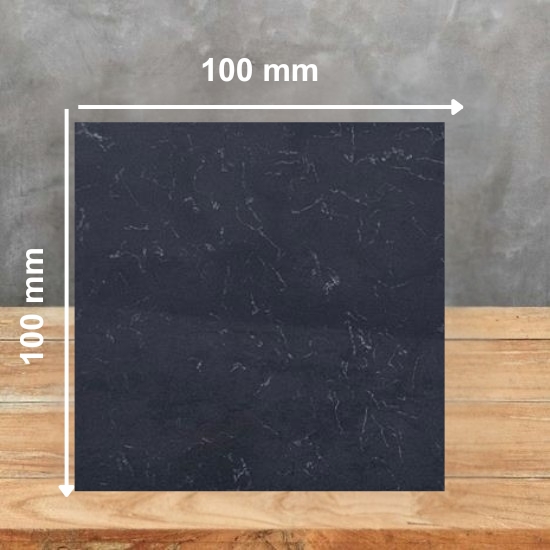 Square sample tile of Carrara Nero quartz in white with black veining, on a wooden table with grey background