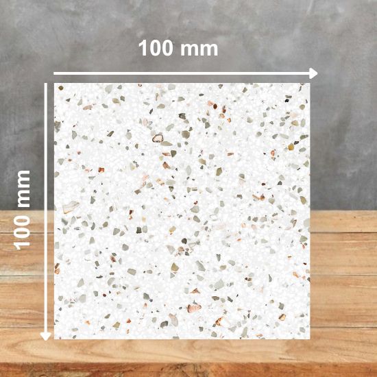00 mm square sample of Quartzforms Terrazzo Gritti quartz in white base with dense grey black beige and copper specks, displayed on wooden surface