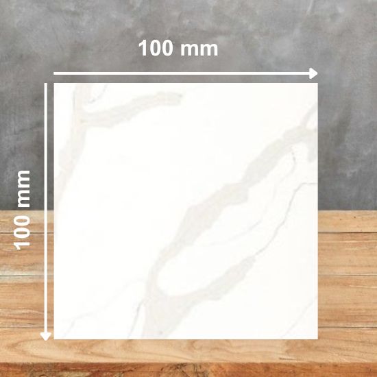 100 mm square sample tile of Calacatta Oro Giant Quartz, bright white with soft grey veins in Calacatta marble-effect pattern, displayed on wooden surface