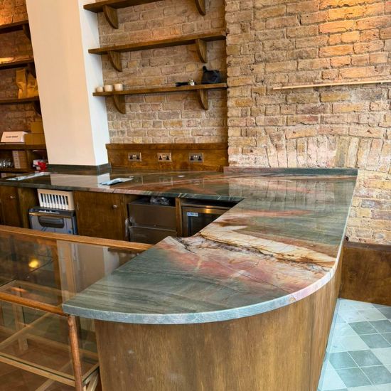 L-shaped Green Maestro Quartzite worktop on wooden base with brick wall background