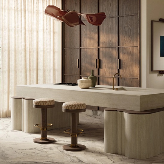 Sapienstone Travessa kitchen island in light beige travertine-effect with linear veining, paired with upholstered bar stools, brass fixtures and warm wood cabinetry in a luxurious modern kitchen
