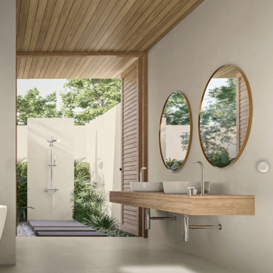 Techlam Limestone bathroom vanity and walls in soft light grey with natural limestone texture, featuring wooden floating vanity, white vessel sinks, round mirrors and open-air shower in a luxurious outdoor bathroom