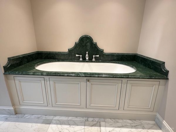 Verde India Marble bathroom vanity top in deep emerald green with white veining, featuring white oval sink and chrome fixtures in an elegant bathroom