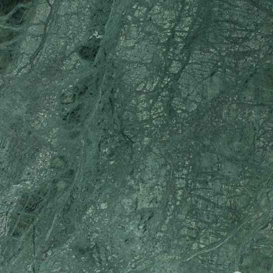 High-resolution close-up of Verde India marble showing rich emerald green base with dramatic white and grey veining