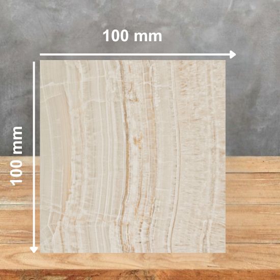 100mm x 100mm physical sample of Caesarstone Onyxa quartz worktop material on wooden surface with scale reference for kitchen worktop selection.